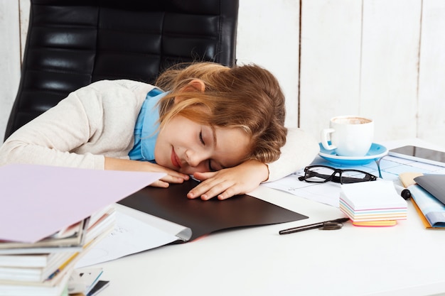 Free photo young beautiful girl sleeping at working place in office.