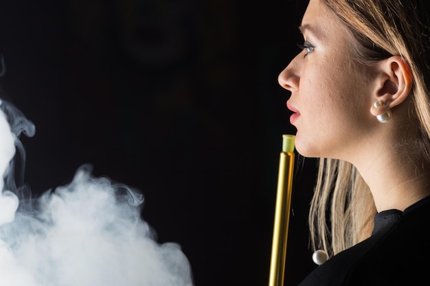 Free photo young beautiful girl smokes a hookah