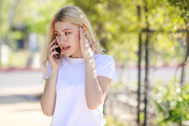 Young beautiful girl talking on the phone and crying