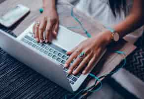 Free photo young beautiful girl uses a laptop in cafe, surfing the internet