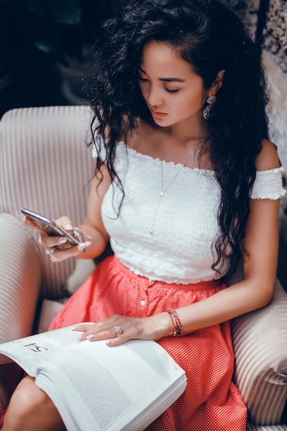 young beautiful girl uses a smartphone on the street, surfing the internet