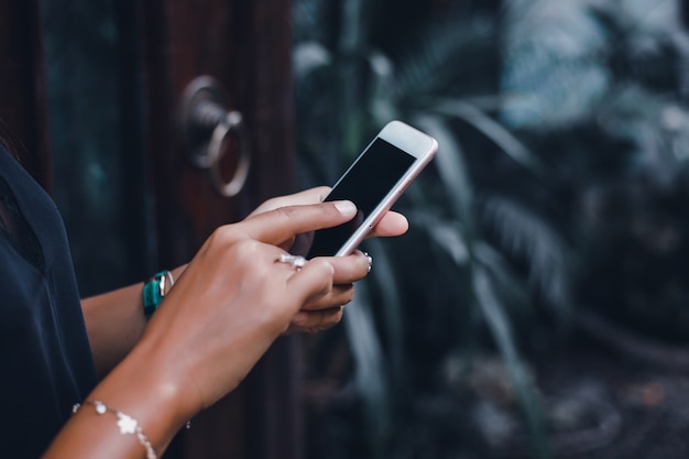 Free photo young beautiful girl uses a smartphone on the street, surfing the internet