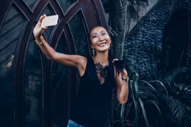 young beautiful girl uses a smartphone on the street, surfing the internet