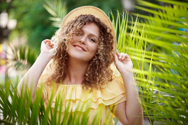 Young beautiful girl in yellow dress posing in city park.