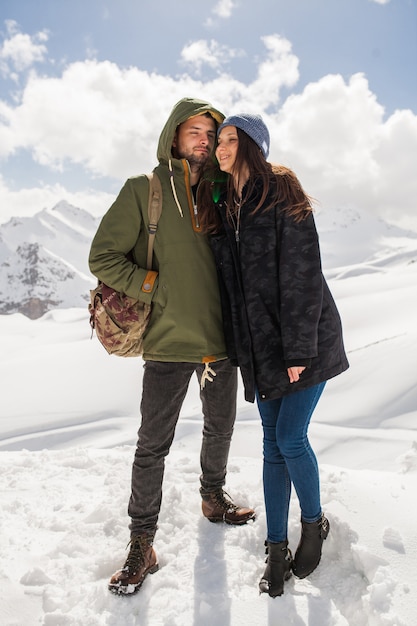 Young beautiful hipster couple hiking in mountains, winter vacation traveling, man woman in love