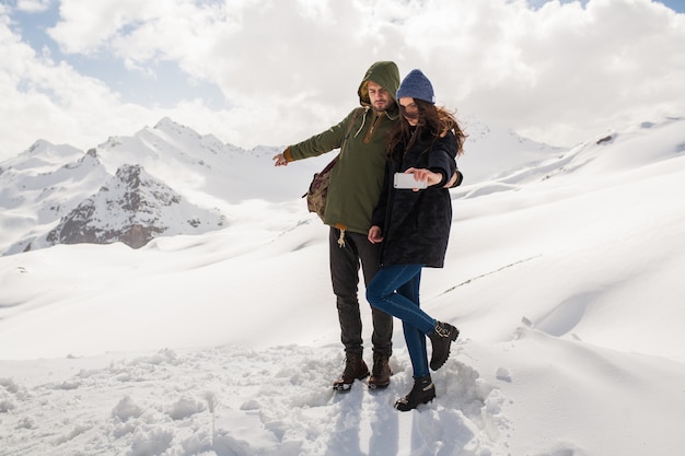 Young beautiful hipster couple hiking in mountains, winter vacation traveling, man woman in love