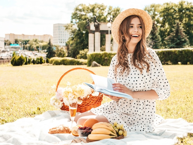 Free photo young beautiful hipster woman in trendy summer sundress and hat. carefree woman making picnic outside.