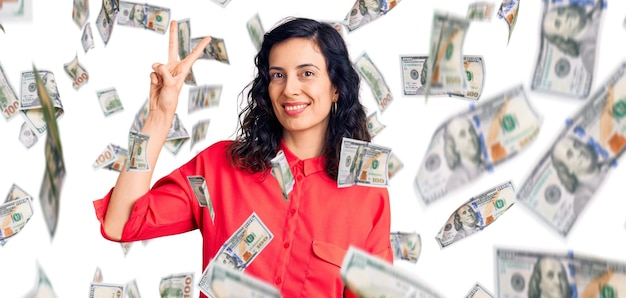 Young beautiful hispanic woman wearing casual clothes showing and pointing up with fingers number two while smiling confident and happy.