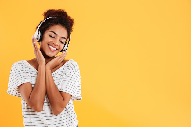 Young beautiful lady with curly hair listening music isolated