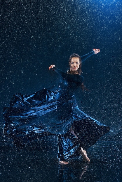 Free photo the young beautiful modern dancer dancing under water drops