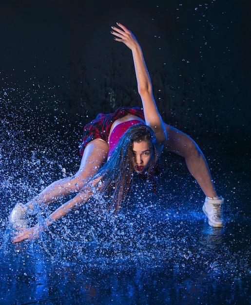 Free photo the young beautiful modern dancer dancing under water drops