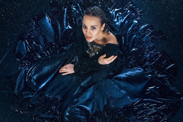 The young beautiful modern dancer posing under water drops