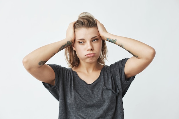 Young beautiful nervous upset girl thinking holding head .