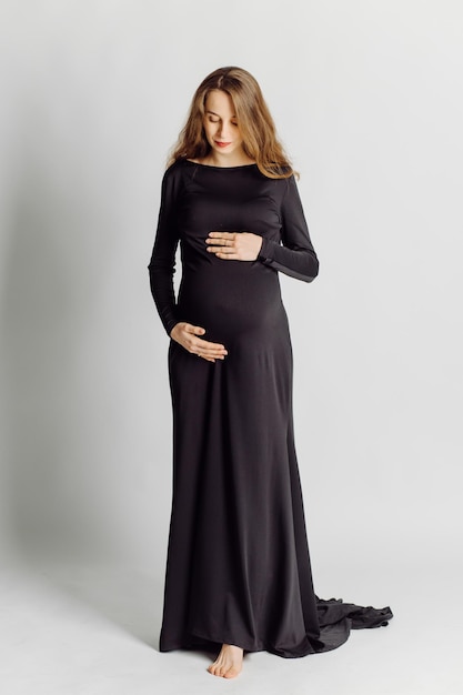 Free Photo young beautiful pregnant woman in black dress pregnancy fashion look concept