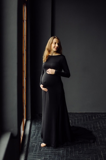 Free Photo young beautiful pregnant woman in black dress pregnancy fashion look concept