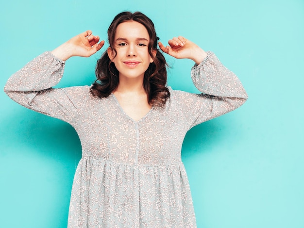 Free photo young beautiful smiling female in trendy summer dress sexy carefree woman posing near blue wall in studio positive model having fun cheerful and happy