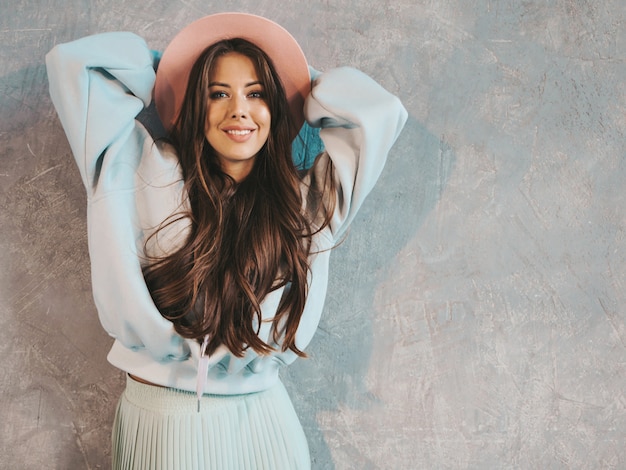 Young beautiful smiling woman looking . Trendy girl in casual summer hoodie and skirt clothes.  