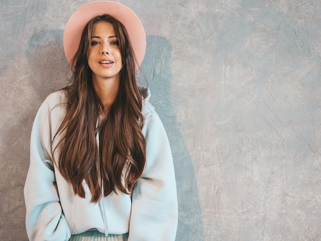 Young beautiful smiling woman looking . Trendy girl in casual summer hoodie and skirt clothes.  