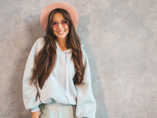 Young beautiful smiling woman looking . Trendy girl in casual summer hoodie and skirt clothes.  