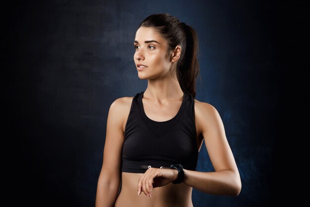  young beautiful sportive girl posing over dark wall.