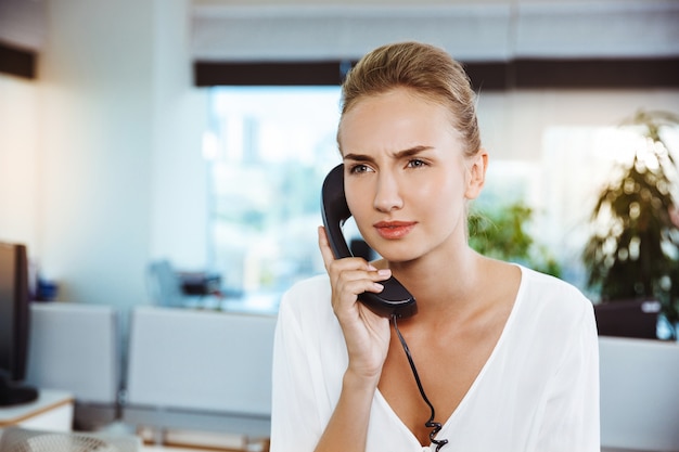 Young beautiful successful businesswoman speaking on phone, over office