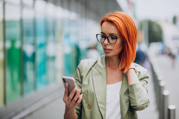 Young beautiful successful woman in green suit talking on the phone