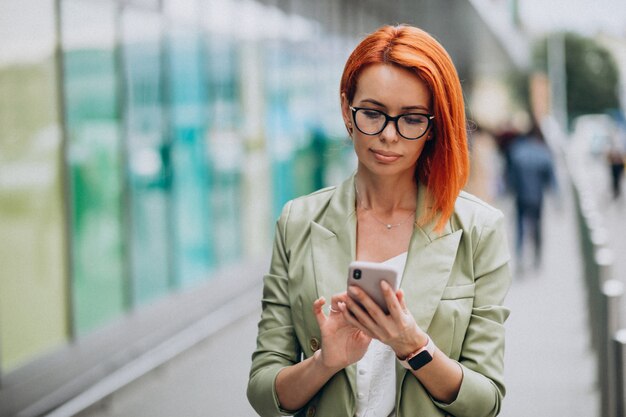 Young beautiful successful woman in green suit talking on the phone