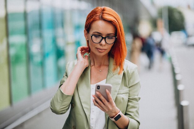 Young beautiful successful woman in green suit talking on the phone