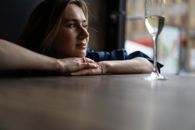 Young beautiful woman in a cafe, a woman drinking champagne in a cafe and talking.