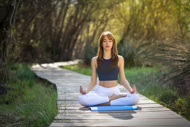 Young beautiful woman doing yoga in nature