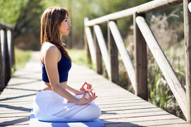 Young beautiful woman doing yoga in nature