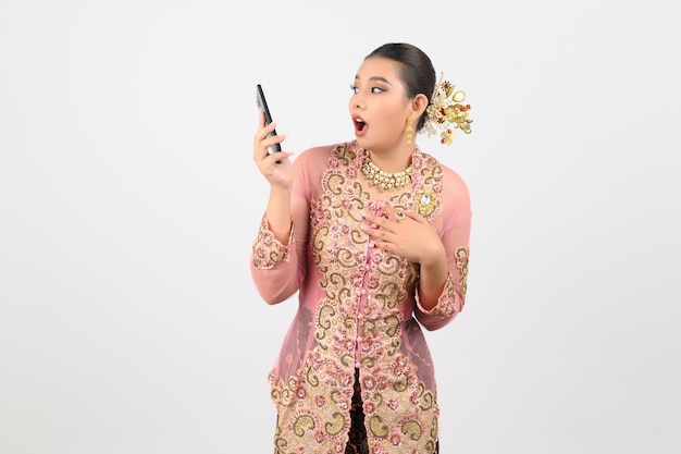 Young beautiful woman dress up in local culture in southern region pose with smartphone