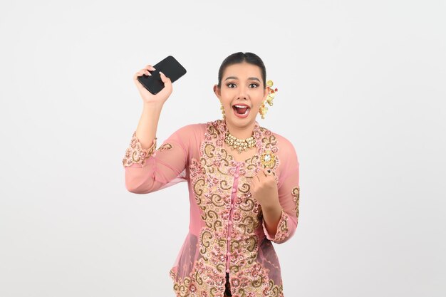 Young beautiful woman dress up in local culture in southern region pose with smartphone