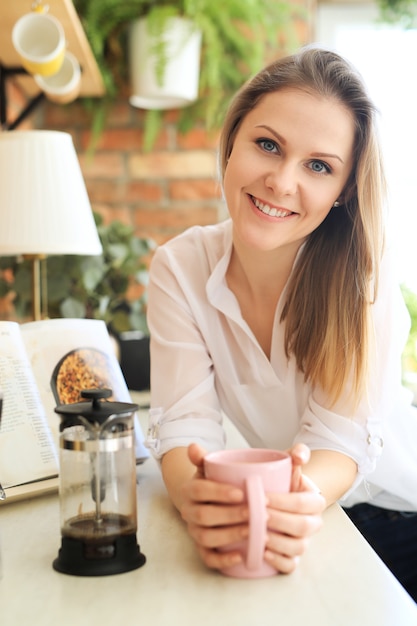 Young beautiful woman drinking coffee or tea