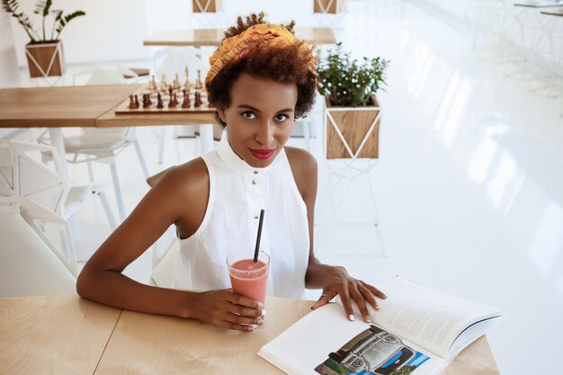 Young beautiful woman drinking smoothie smiling resting in cafe