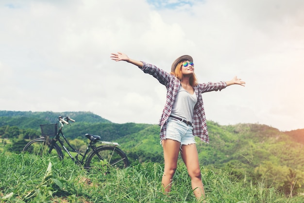 Young beautiful woman enjoying freedom and life in nature behind