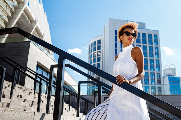 Young beautiful woman going up stairs walking down city