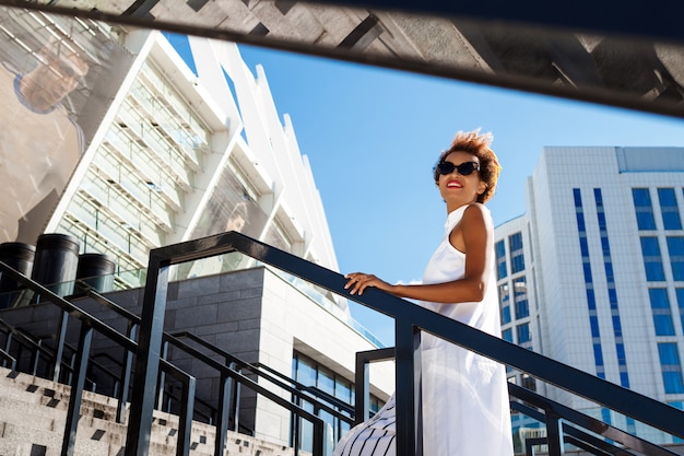 Free Photo young beautiful woman going up stairs walking down city