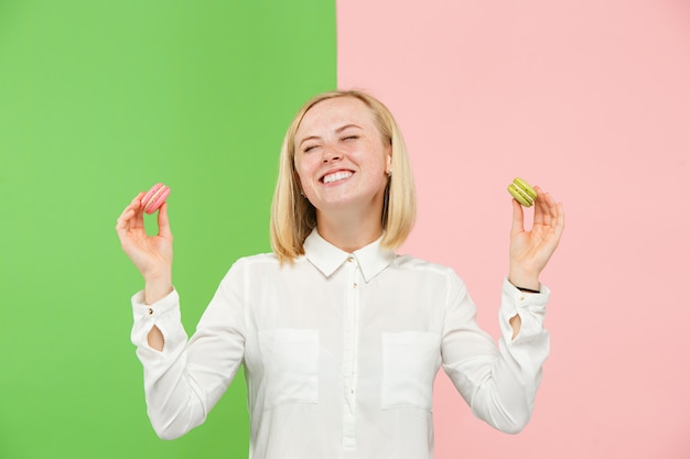 Free photo young beautiful woman holding macaroons pastry in her hands