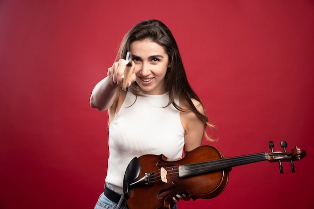 Free Photo young beautiful woman holding a violin 