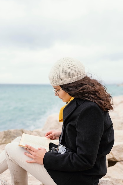 Young beautiful woman in nature reading book