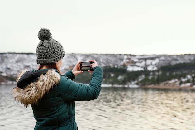 Free Photo young beautiful woman in nature taking photos