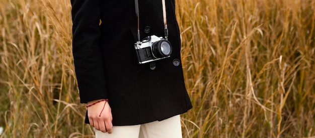 Young beautiful woman in nature with camera close up