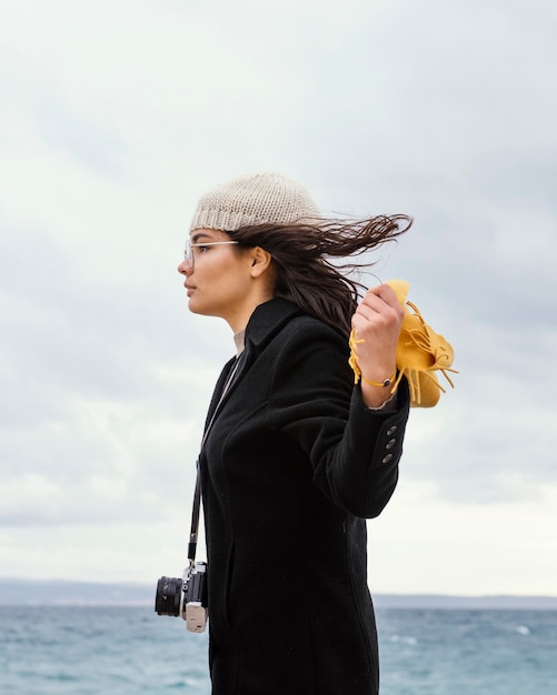 Young beautiful woman in nature with camera