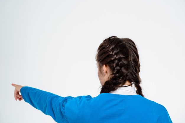 Free Photo young beautiful woman pointing finger away over white wall