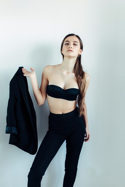 Young beautiful woman posing on a white wall