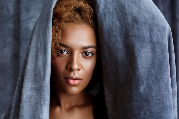 Free photo young beautiful woman posing, wrapping up  in grey cloth