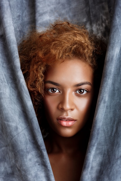 Free photo young beautiful woman posing, wrapping up  in grey cloth