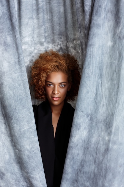 Young beautiful woman posing, wrapping up  in grey cloth