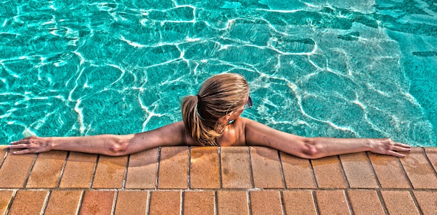 Free Photo a young beautiful woman relaxes at the swimming pool. wellness concept. spa and relax, woman happiness.